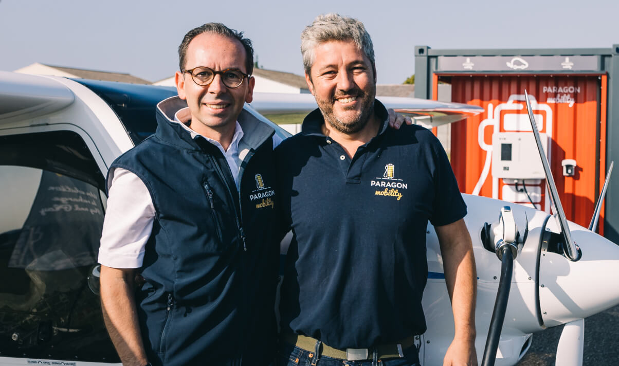 Jean Lemaire and Yann Cortot, Founders of Paragon Mobility, in front of the Nano Pod charging an electric plane.